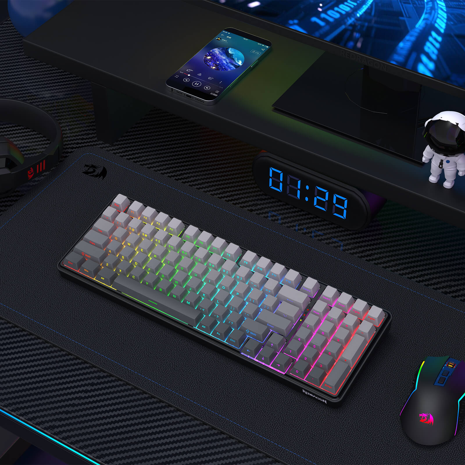 Gaming keyboard with RGB lighting on a desk setup with phone, mouse, and decor.